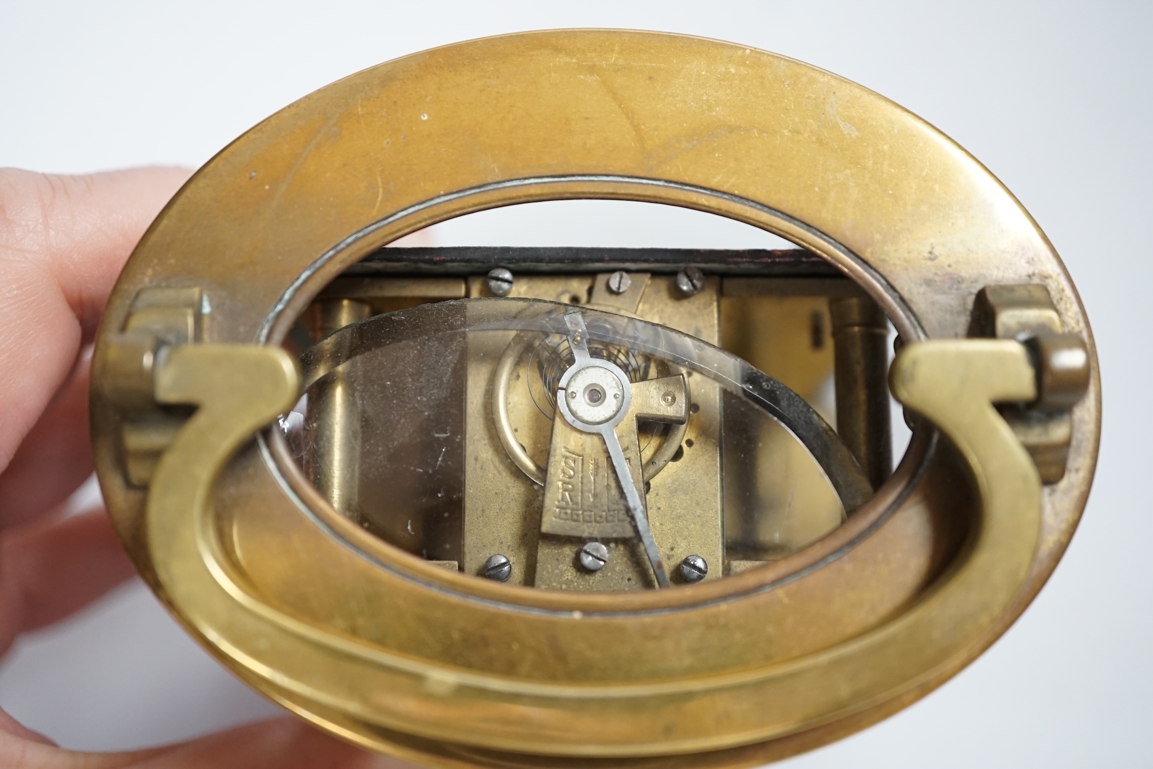 A brass oval cased carriage timepiece, stamped ‘Made in France’, 12cm